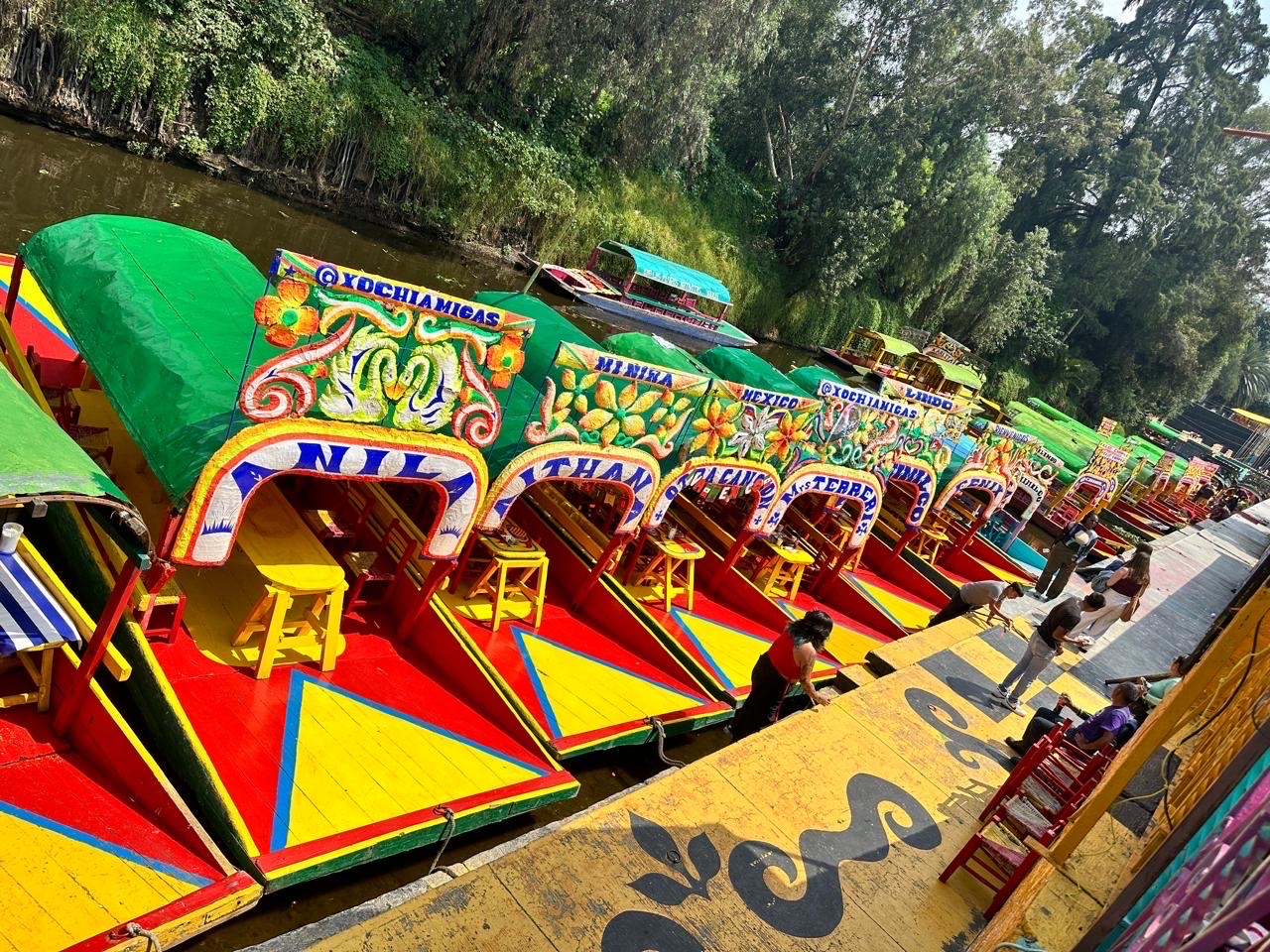 Fila de trajineras coloridas en el embarcadero de Xochimilco